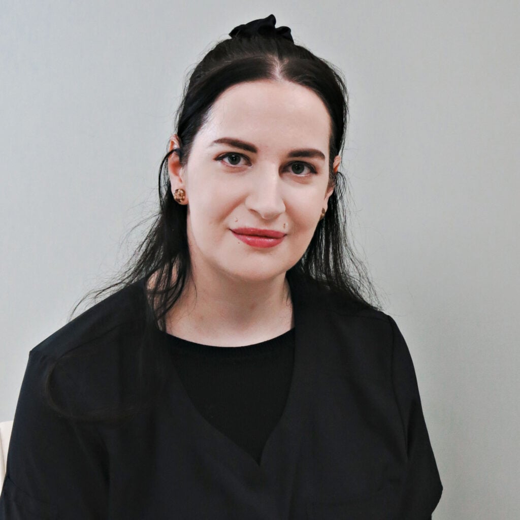 Woman with long dark hair wearing black shirt facing camera