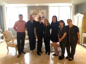Group of professionals in a well-lit room posing together