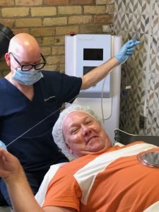 Man receiving cosmetic skin treatment in clinic room