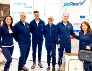 Group of professionals in blue attire at JetPeel skincare technology booth