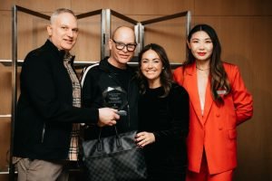 Group of people holding an award in a modern setting
