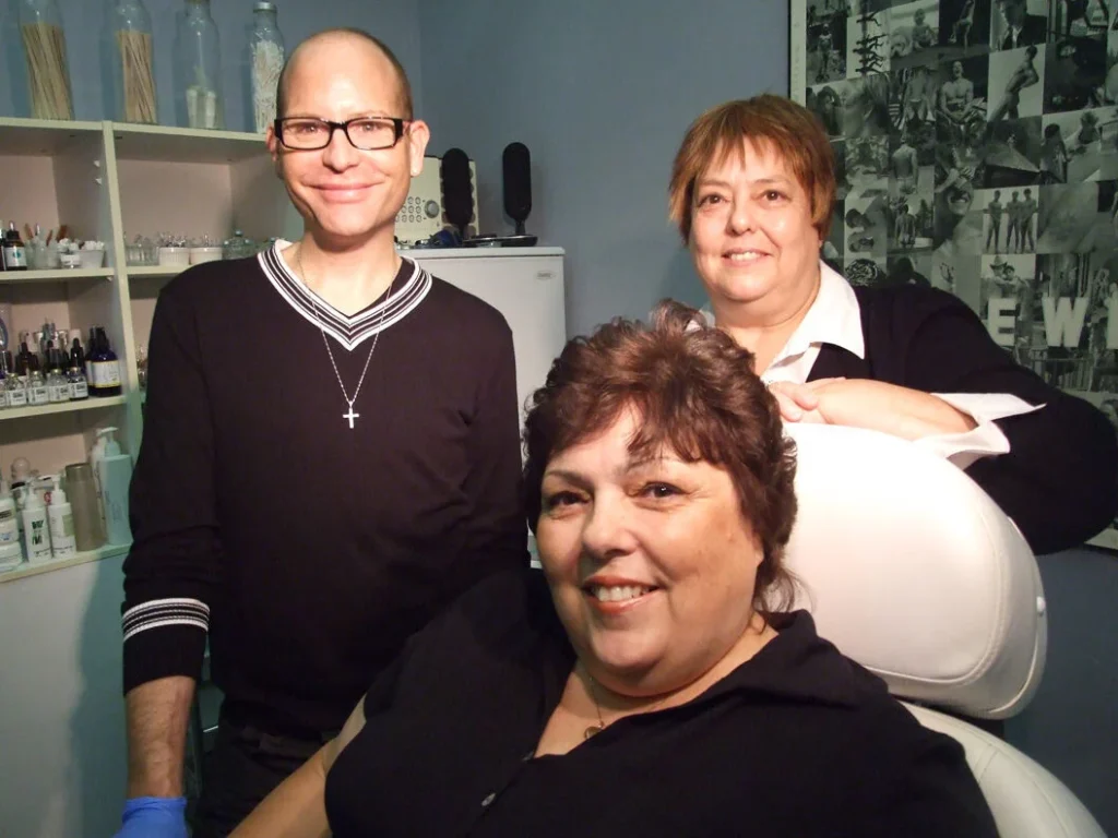 Three smiling people in a clinic with beauty products