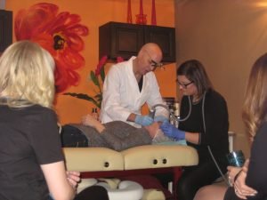 Aesthetic clinic team performing facial treatment on a client