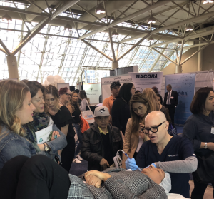 Cosmetic procedure demonstration at medical conference with audience observing