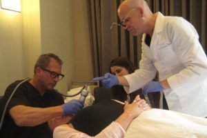 Medical professionals conduct a skin treatment procedure with laser equipment