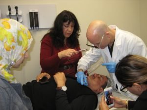 Doctors examine patient during medical procedure in clinic