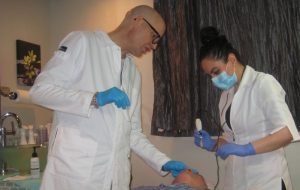 Medical professionals performing a facial treatment on a patient