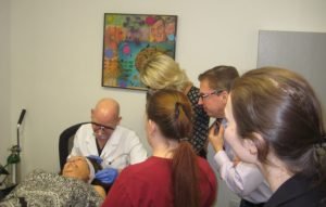 Medical team observes a cosmetic procedure being performed in a clinic