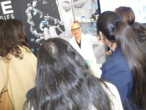 Expert demonstrating skincare techniques to a captivated audience