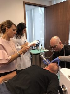 Medical team performing skin treatment on patient in clinic