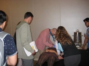 Hands-on chiropractic adjustment training session with practitioners and observers