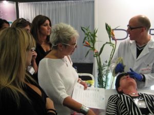 Dermatologist demonstrating facial procedure at a skincare event
