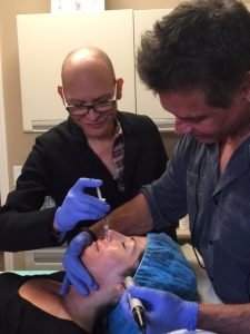Medical professionals performing cosmetic injections on a patient's face