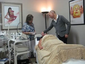 Spa professionals applying a gold facial treatment to a client