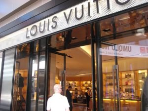 Louis Vuitton store entrance with luxury handbags display